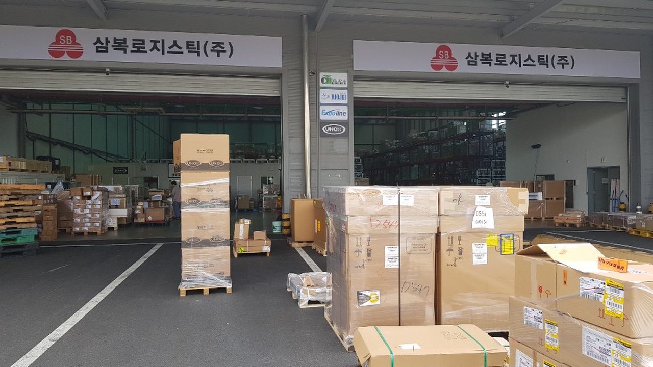 삼복로지스틱㈜ 인천공항 자유무역지역 창고 반입구 — 파렛트 화물이 놓인 상하차 구역